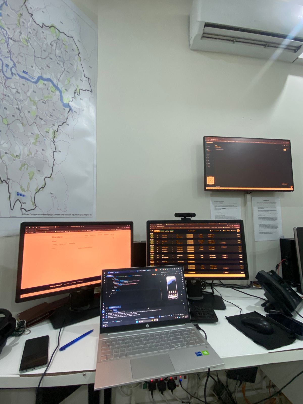 Multi-monitor office setup during TankerNow development, with a map of Islamabad on the wall